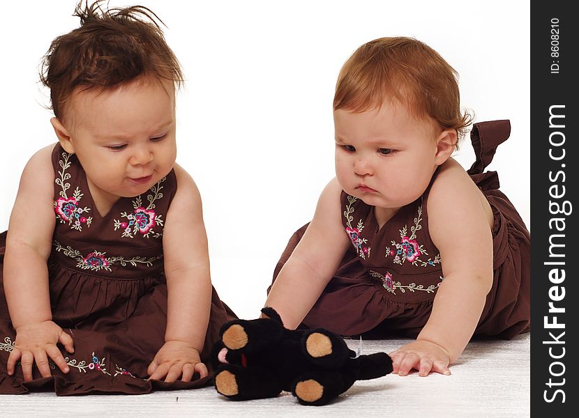 Two adorable little babies wearing brown dresses isolated against white background. Two adorable little babies wearing brown dresses isolated against white background