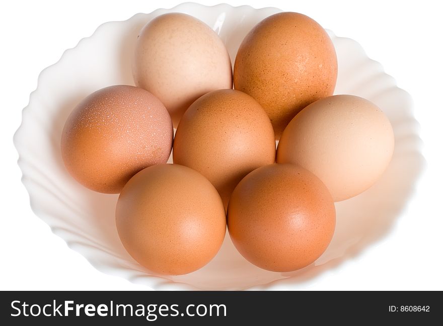 Seven eggs on plate, isolated over white