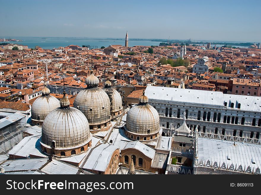 An aerial view of Venice, Italy, showing the traditional domes, the terra cotta roofs, and the Piazza San Marco below. An aerial view of Venice, Italy, showing the traditional domes, the terra cotta roofs, and the Piazza San Marco below.