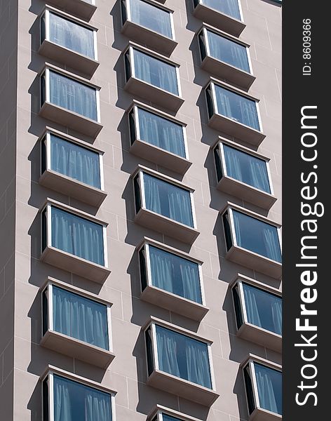 Columns of overhanging windows making the facade of a hotel in modern style architecture. Columns of overhanging windows making the facade of a hotel in modern style architecture