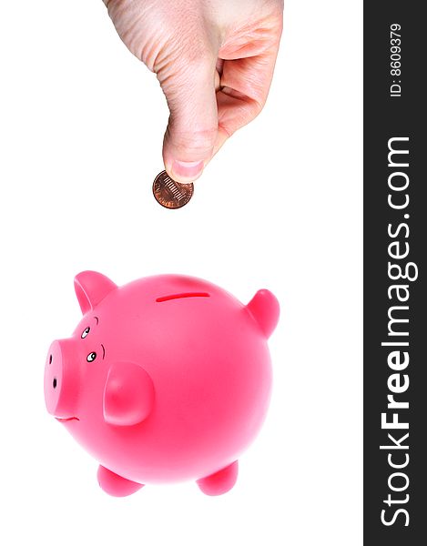 Hand Inserting Coin Into Piggy Bank