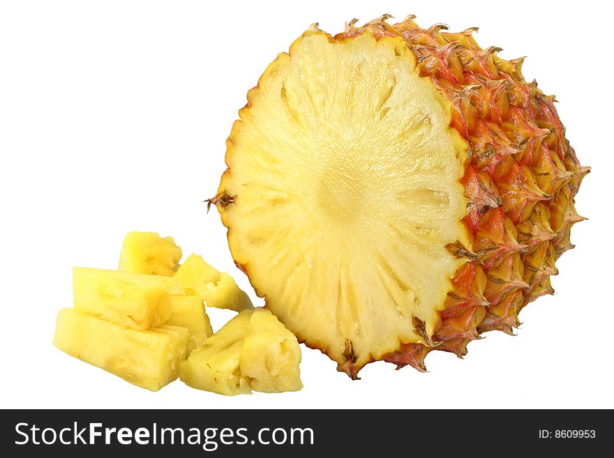 Yellow ripe pineapple with skin on and small pieces in the front on white background