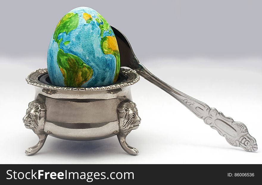 The earth in the image of the egg lies on a plate before dinner time. The earth in the image of the egg lies on a plate before dinner time