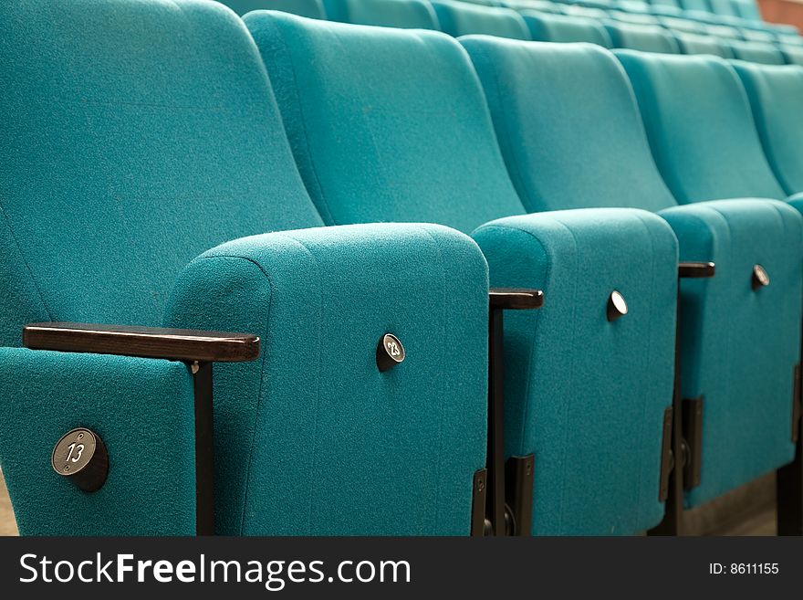 Row number thirteen. Row of green chairs in auditorium. Row number thirteen. Row of green chairs in auditorium.