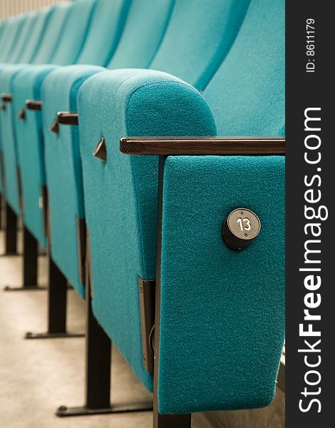 Row number thirteen. Row of green chairs in auditorium. Row number thirteen. Row of green chairs in auditorium.