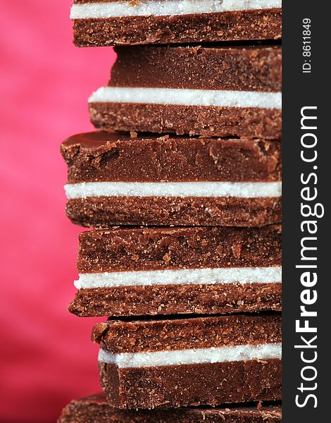 Close-up of chunks of black and white chocolate on vivid pink background. Close-up of chunks of black and white chocolate on vivid pink background