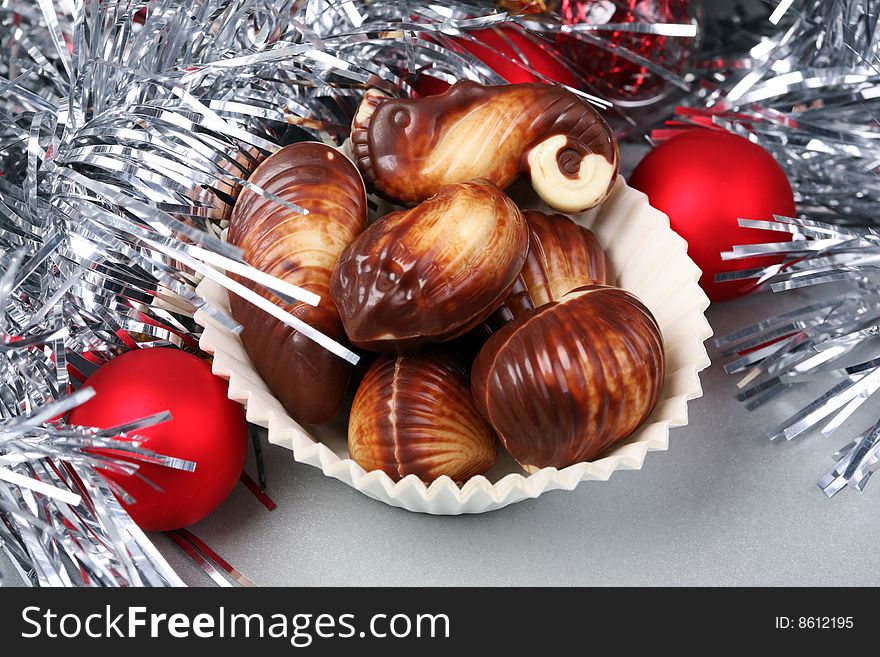 Seashell shaped pralines surrounded by Christmas decoration. Seashell shaped pralines surrounded by Christmas decoration