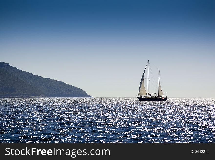 Seascape and a yacht sailing the Mediterranean on a bright sunny day