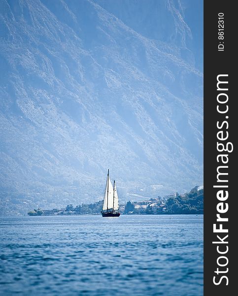 Yacht sailing the Mediterranean on a bright sunny day with distant mountains in blue mist on the background. Yacht sailing the Mediterranean on a bright sunny day with distant mountains in blue mist on the background