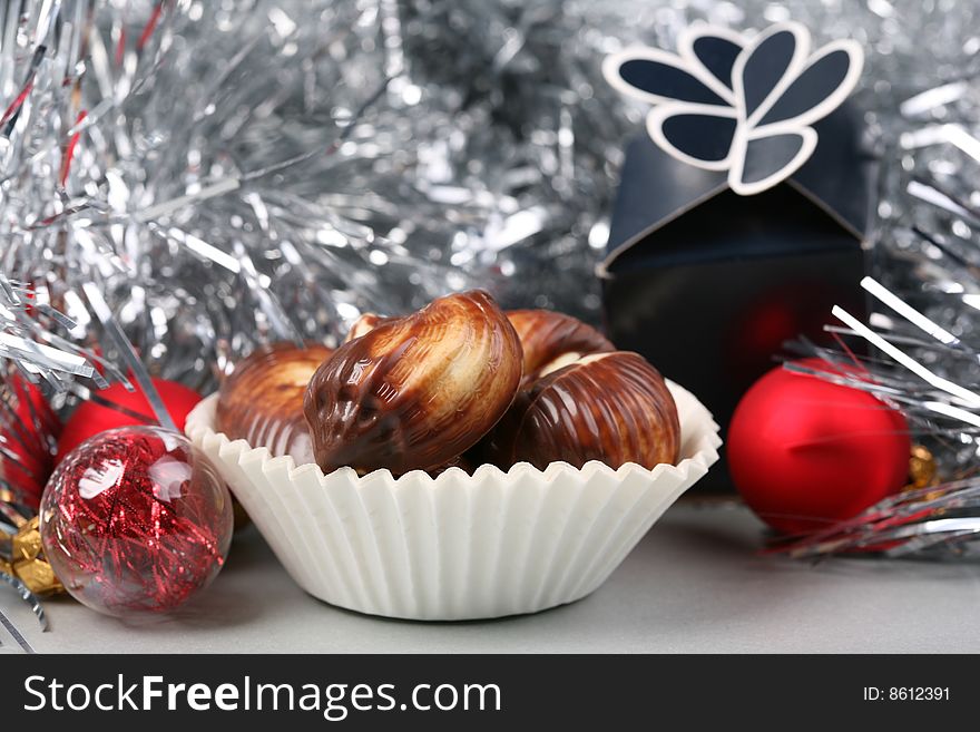 Seashell shaped pralines surrounded by Christmas decoration. Seashell shaped pralines surrounded by Christmas decoration