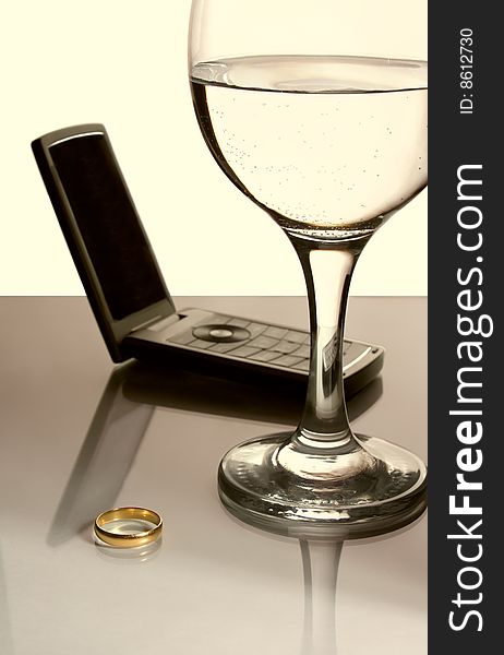 Gold ring, phone and glass. Gold ring, phone and glass.