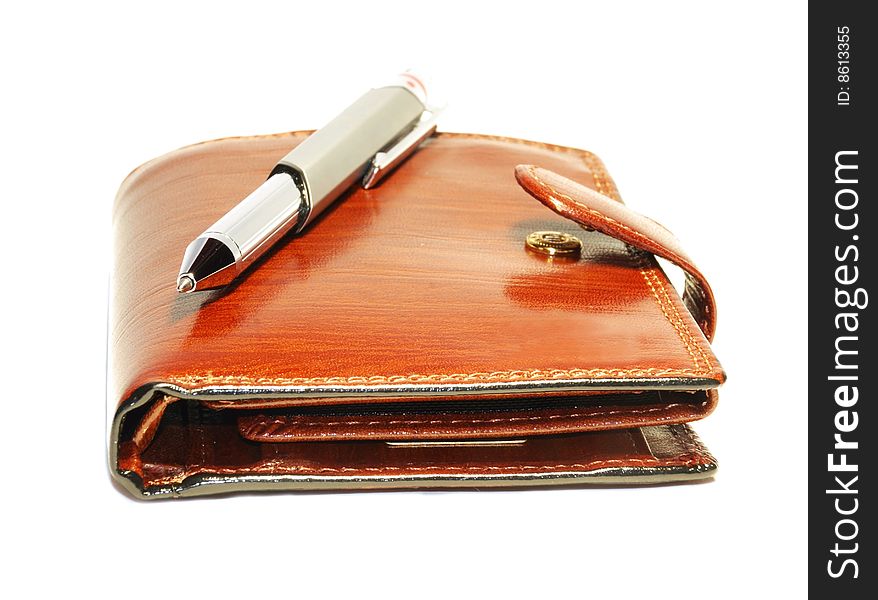 A leather masculine purse and metallic pen is isolated on white. A leather masculine purse and metallic pen is isolated on white