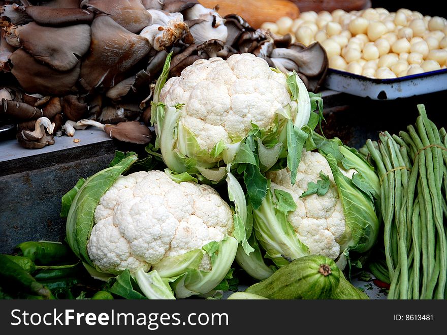 Mushrooms, green beans, garlic, and three large heads of cauliflower at the Tian Fu outdoor market in Pengzhou, Sichuan province, China - Lee Snider Photo. Mushrooms, green beans, garlic, and three large heads of cauliflower at the Tian Fu outdoor market in Pengzhou, Sichuan province, China - Lee Snider Photo.