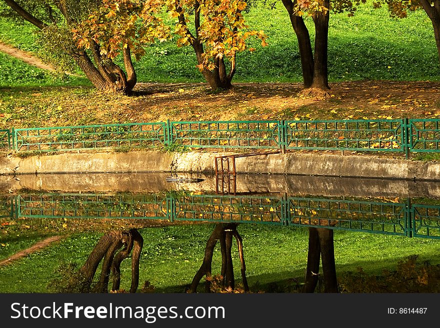 An autumn view of trees reflecting in water. An autumn view of trees reflecting in water