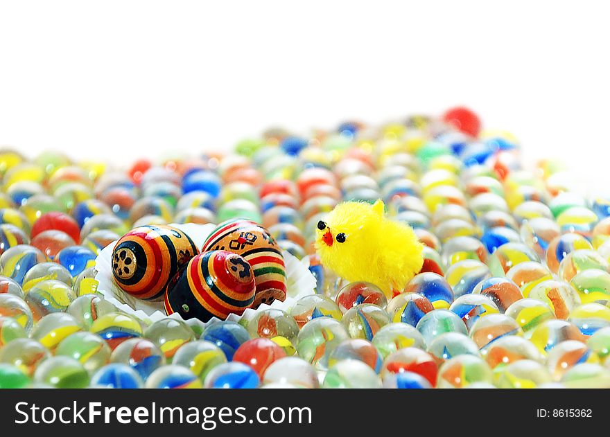 Bright easter background, a chicken among glass marbles finds a nest with eggs.