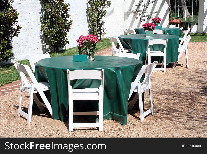 Several tables are in an outdoor patio area waiting for guests to dine. Several tables are in an outdoor patio area waiting for guests to dine.