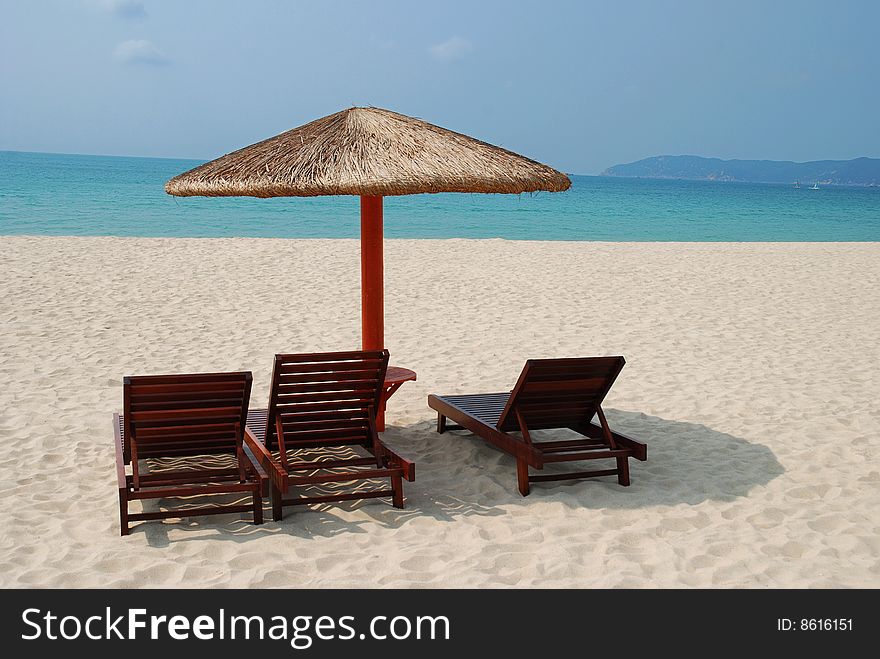 Wooden reclining chairs and umbrella in a beautiful Beach. Wooden reclining chairs and umbrella in a beautiful Beach