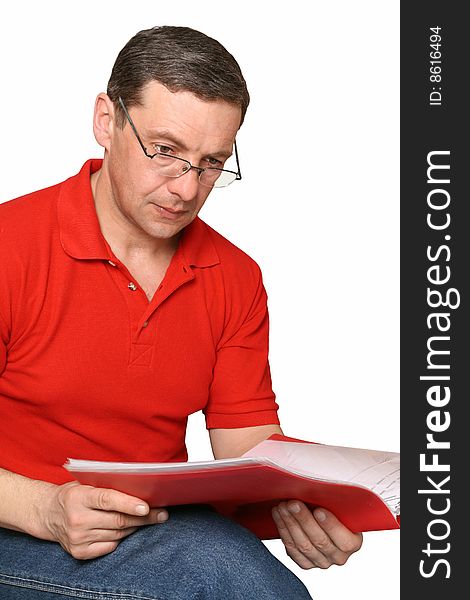 The man in glasses studies documents in a red folder. The man in glasses studies documents in a red folder