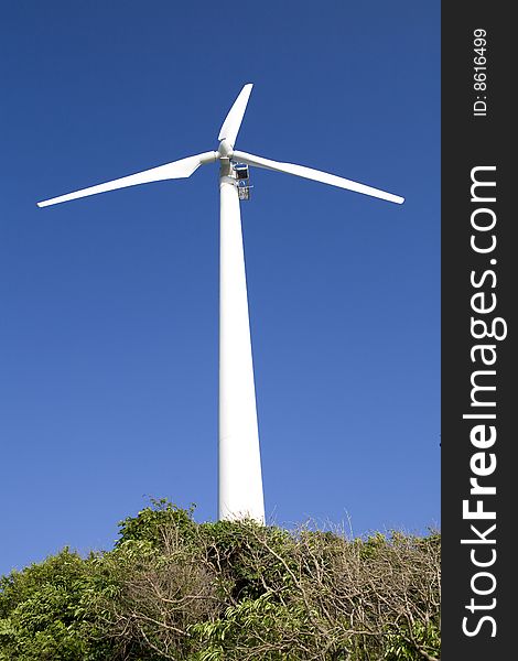 A white wind generator and blue sky. A white wind generator and blue sky