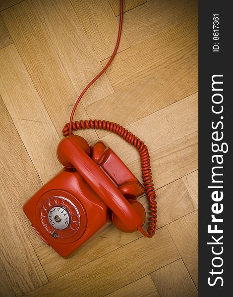 Old red telephone laying on the floor