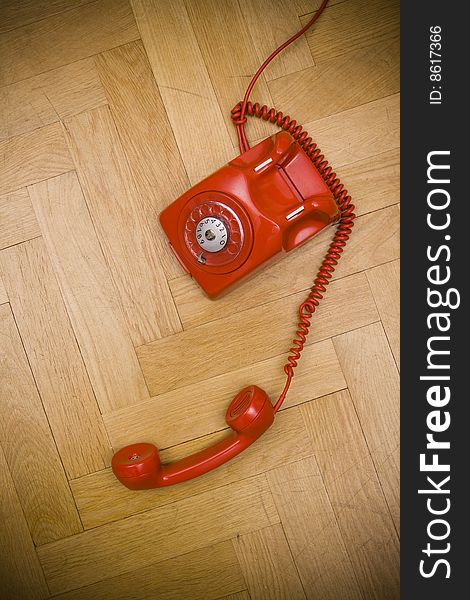 Old red telephone laying on the floor