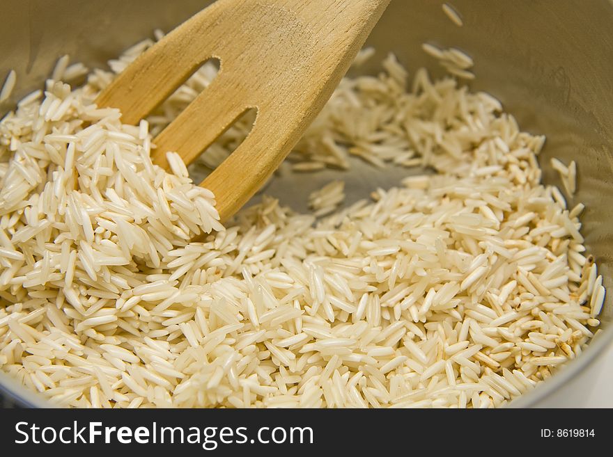 Stirring rice in a pot with a wooden spoon