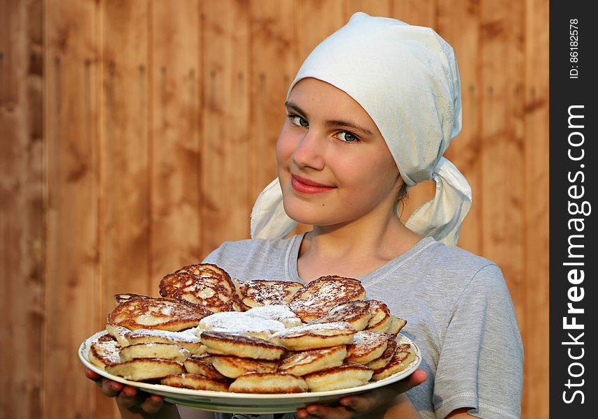 Woman in Grey Crew Neck Shirt Holding a White Ceramic Plate With Pancakes