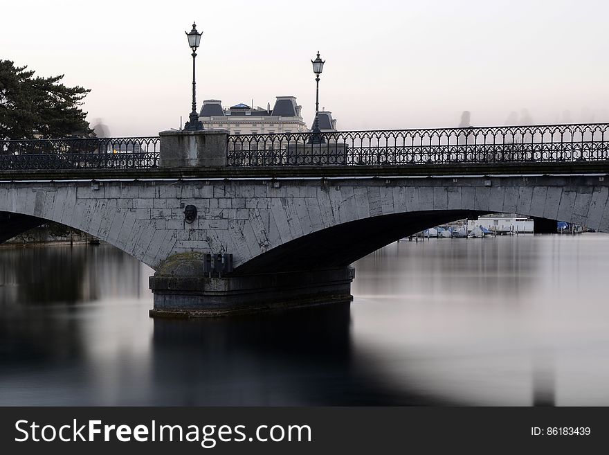 Grey Bridge With Light Post Under White Sky during Daytime