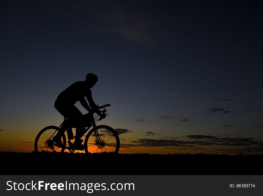 Man Riding Bicycle during Nightfall