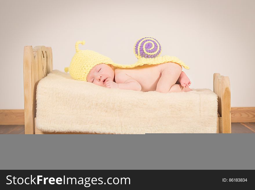 A baby on tiny bed with snail costume. A baby on tiny bed with snail costume.