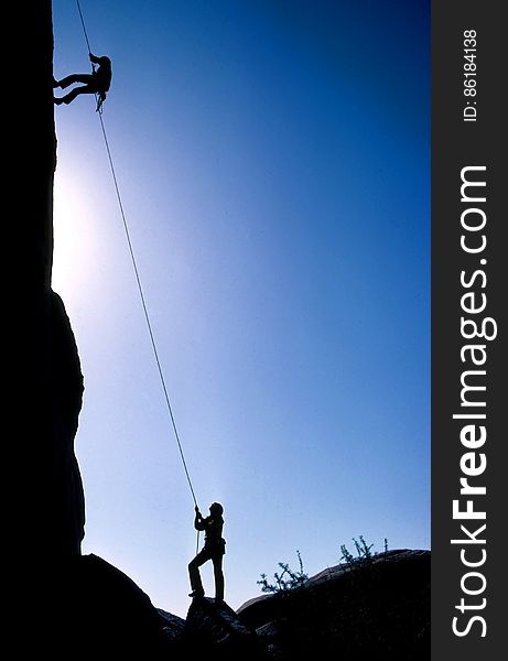 Silhouette of climbers on cliff