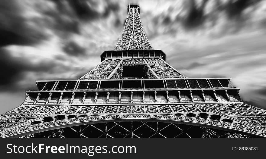 Black and white facade of Eiffel Tower in Paris, France from below with cloudy skies. Black and white facade of Eiffel Tower in Paris, France from below with cloudy skies.