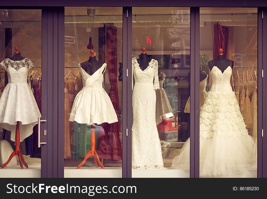 Display of white long and short bridal gowns in window of store. Display of white long and short bridal gowns in window of store.