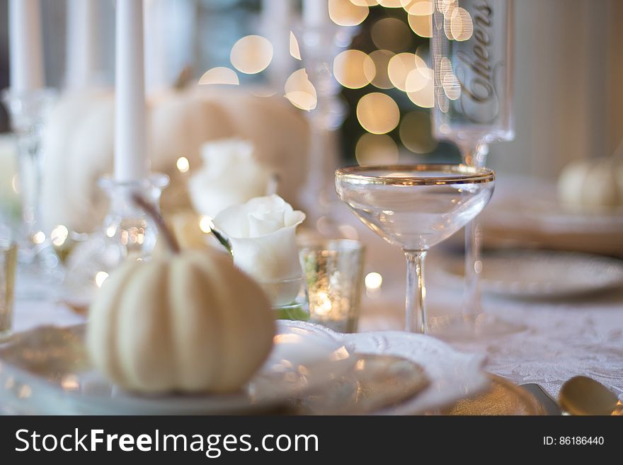 A close up of elegant table setting and decorative garlic on a ceramic saucer.