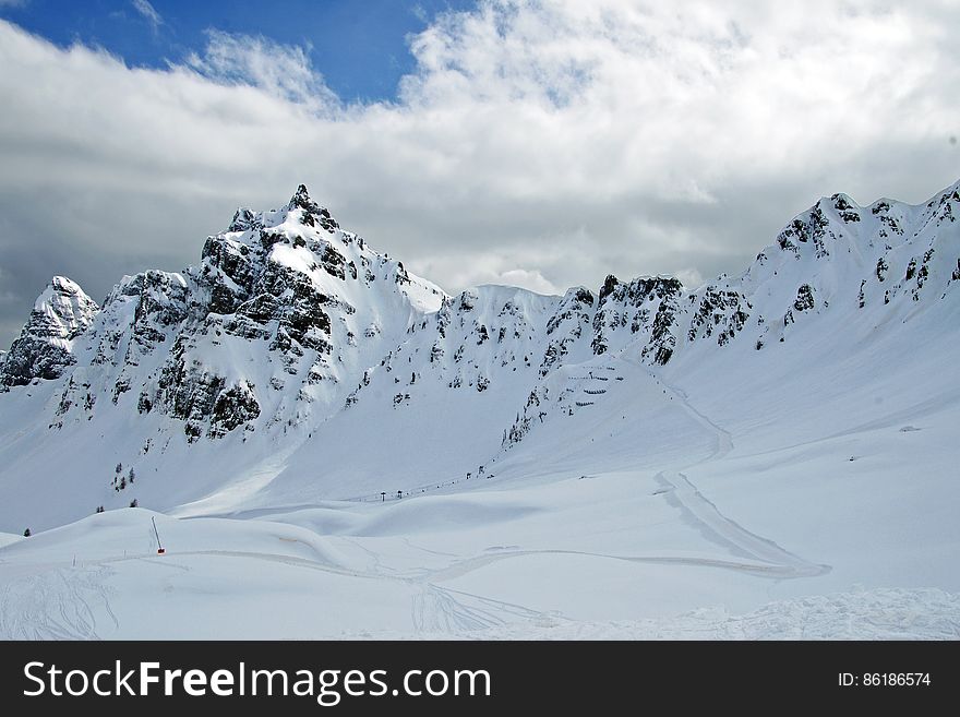 Skiers performing extreme skiing on steep rocky slopes of the Alps. Skiers performing extreme skiing on steep rocky slopes of the Alps.