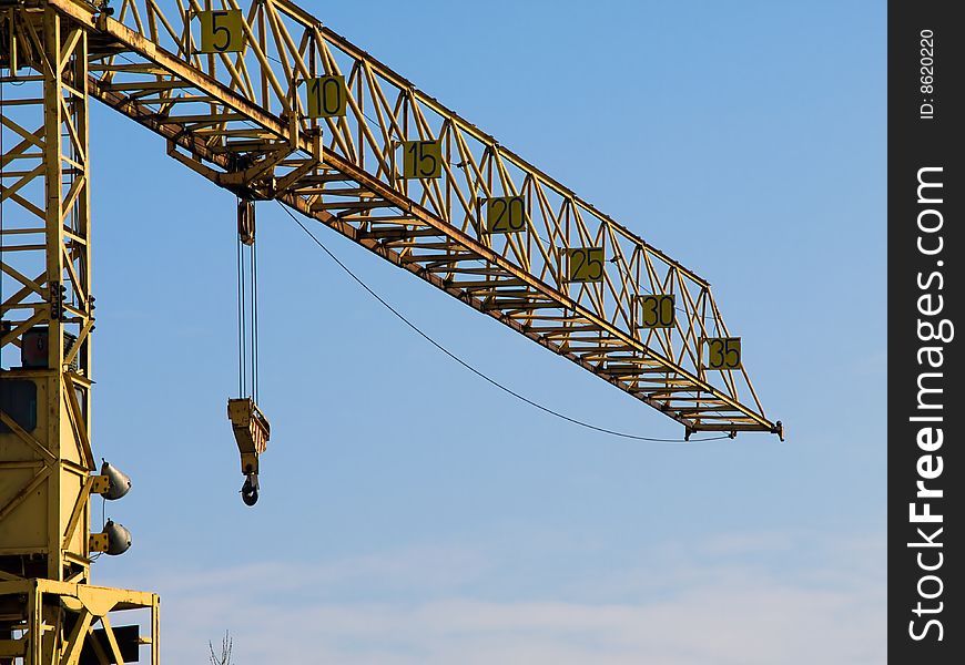 A large yellow crane with blue skies in the background