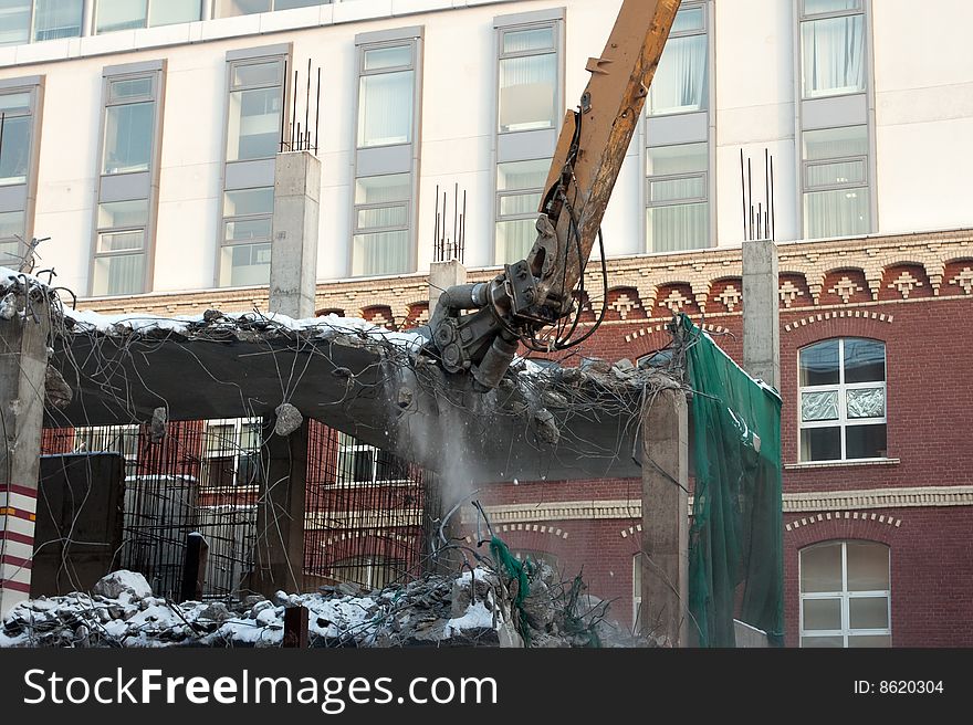 Heavy dredger is demolishing a house. Heavy dredger is demolishing a house