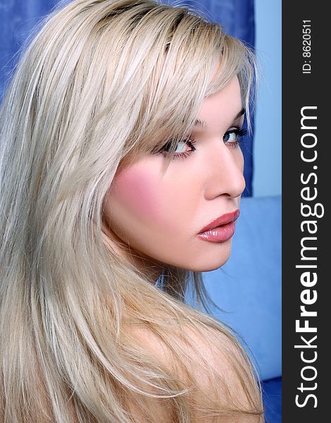 Young blondie girl against blue background