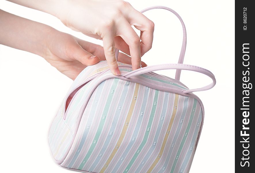 The female hand holds a white women handbag. The female hand holds a white women handbag