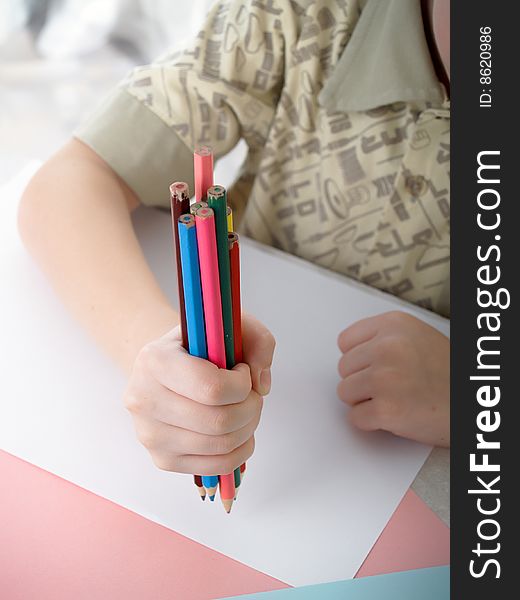 Boy draws pencils sitting for a table. Boy draws pencils sitting for a table