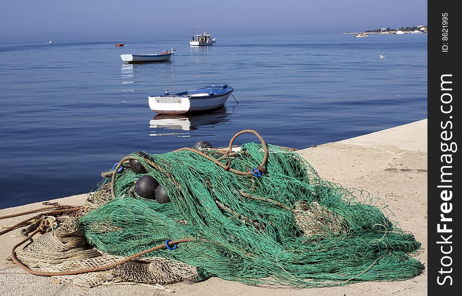 Picture taken in port of Novalja, island Pag, Croatia. Fishing net and fishing boats on Sunday. Picture taken in port of Novalja, island Pag, Croatia. Fishing net and fishing boats on Sunday.