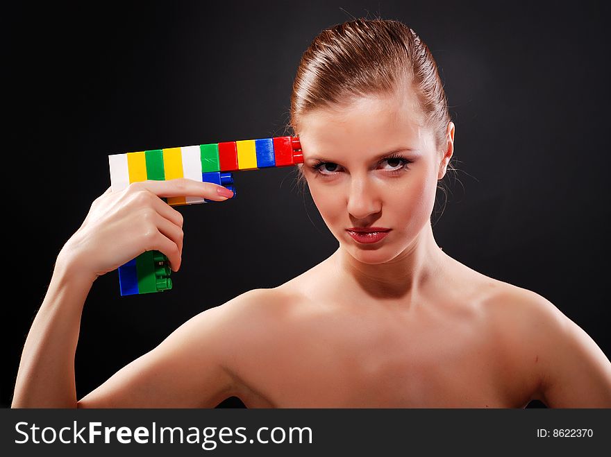 Portrait of young beautiful woman with toy gun