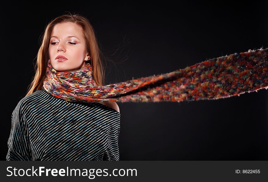 Young woman in color wool scarf at black background. Young woman in color wool scarf at black background