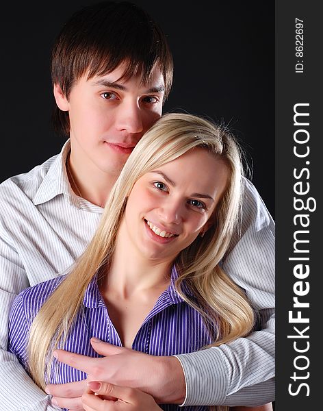 Young loving couple isolated at black background