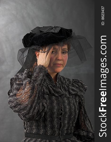 The woman in black clothes with a sick head on a grey background. The woman in black clothes with a sick head on a grey background.