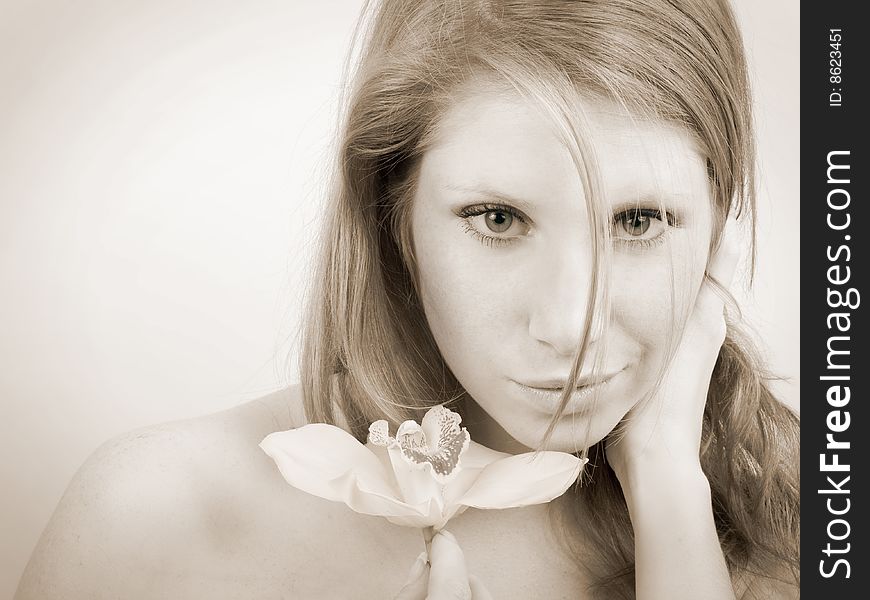Beautiful girl with an orchid on white, sepia shot. Beautiful girl with an orchid on white, sepia shot