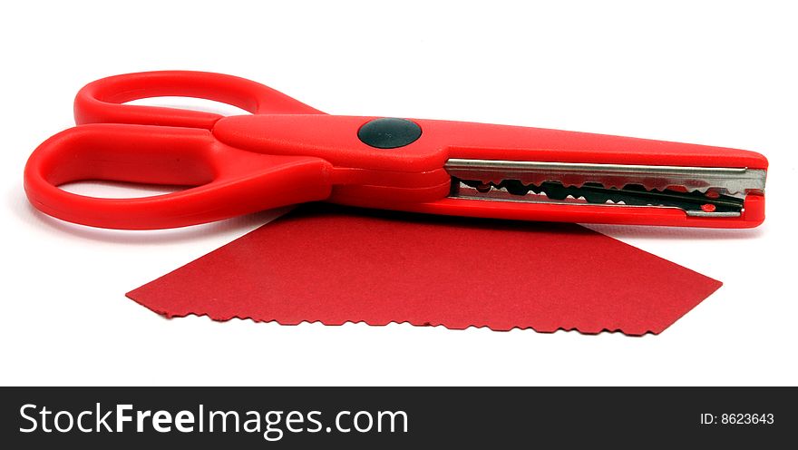 Red serrated scissors and cut paper. Red serrated scissors and cut paper