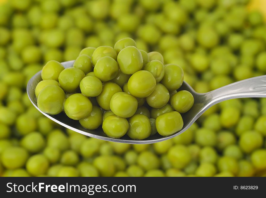 Closeup of spoonful of green peas