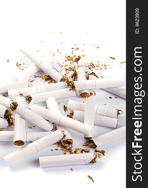 Broken cigarettes closeup on white background