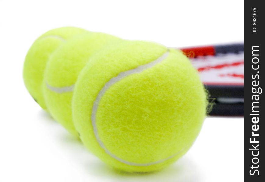 Three tennis ball with racket in background